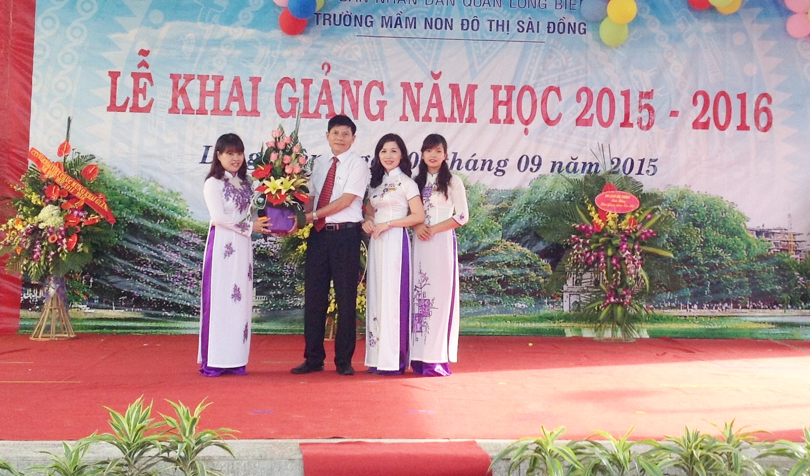 Ông Hoàng Văn Tiến – Đảng ủy viên – Phó CTHĐND tặng hoa cho nhà trường