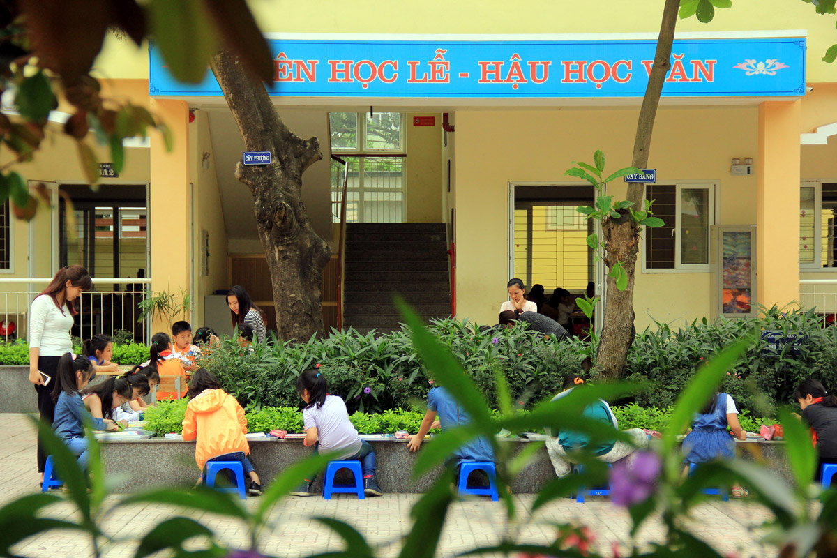 Hình ảnh các em học sinh ngồi vẽ tại khu vực sân trường