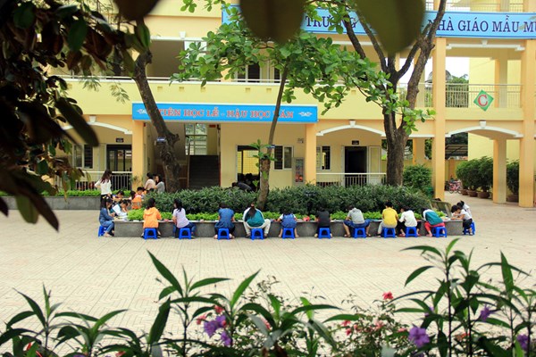 Hình ảnh các em học sinh ngồi vẽ dưới các hàng cây xanh mát
