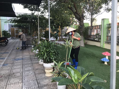 Nhân viên nuôi dưỡng trường mầm non Hồng Tiến vệ sinh cảnh quan môi trường hàng ngày